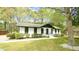 Well-maintained home with a white exterior, black trim, and beautiful front yard at 909 Windcrest Rd, Durham, NC 27713