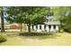 Charming home featuring a well-manicured front yard with mature trees and fresh landscaping at 909 Windcrest Rd, Durham, NC 27713