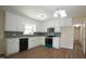 Updated kitchen features white cabinets, stone countertops, and modern appliances at 909 Windcrest Rd, Durham, NC 27713