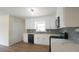 Updated kitchen features white cabinets, stone countertops and modern appliances at 909 Windcrest Rd, Durham, NC 27713