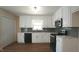 Updated kitchen features white cabinets, stone countertops and modern appliances at 909 Windcrest Rd, Durham, NC 27713