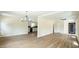 Open-concept living area with wood-look floors, leading to the kitchen with bright lighting at 909 Windcrest Rd, Durham, NC 27713