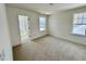 Cozy bedroom with neutral carpet, two windows, and a doorway leading to another room at 91 Brooklynn Trl # 187, Angier, NC 27501