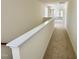 Upstairs hallway with neutral carpet and white trim leading to various rooms, with ample natural light at 91 Brooklynn Trl # 187, Angier, NC 27501