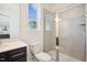 Modern bathroom features a walk-in shower, dark vanity, and window providing natural light and a backyard view at 9512 Wood River Dr, Zebulon, NC 27597