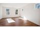 Sun-filled bedroom featuring three windows, luxury vinyl plank flooring, and fresh white walls at 9512 Wood River Dr, Zebulon, NC 27597