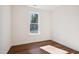 A bright, empty bedroom with LVP flooring, featuring neutral walls and a window with a view of mature trees at 9512 Wood River Dr, Zebulon, NC 27597