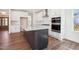 Modern kitchen features white cabinets, a large center island with marble countertop, and stainless steel appliances at 9512 Wood River Dr, Zebulon, NC 27597