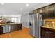 Open kitchen with stainless steel appliances, an island sink, and dark wood cabinets at 989 Ambergate Sta, Apex, NC 27502