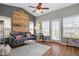 Inviting living room features unique pallet wall art, a grey couch, and three windows providing natural light at 989 Ambergate Sta, Apex, NC 27502