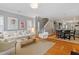 Open-concept living area featuring hardwood floors, neutral furniture, and a dining area at 989 Ambergate Sta, Apex, NC 27502