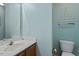 Bright bathroom with modern toilet, vanity, sink, a mirror and decorative wall art at 1003 Buckhorn Rd, Garner, NC 27529