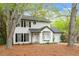 Charming two-story home featuring white siding, black shutters, and mature trees in a well-maintained landscape at 1003 Buckhorn Rd, Garner, NC 27529