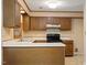 Traditional kitchen featuring wooden cabinets, white countertops, and black appliances at 1003 Buckhorn Rd, Garner, NC 27529
