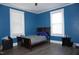 Cozy bedroom with blue walls, wood floors, and natural light from two windows at 10095 N Walnut St St, Middlesex, NC 27557