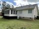 Back of the house with sunroom and wooden deck, featuring white siding at 103 Kiowa Cv, Louisburg, NC 27549