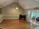 Living room with wood floors, fireplace, vaulted ceiling, and access to sunroom at 103 Kiowa Cv, Louisburg, NC 27549