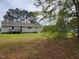 Spacious backyard featuring a well-maintained lawn and a gray wooden deck attached to the house at 1033 Silas Moore Rd, Benson, NC 27504