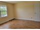 Bright bedroom with laminate flooring, window view, and a white door at 1033 Silas Moore Rd, Benson, NC 27504