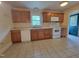 Well-lit kitchen featuring oak cabinetry, white appliances, and easy access to blue door at 1033 Silas Moore Rd, Benson, NC 27504