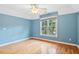 Bedroom with a ceiling fan, hardwood floors, a large window, and painted blue walls at 10370 Spaight, Chapel Hill, NC 27517