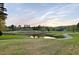 Scenic view of the community golf course, with a tranquil pond and lush greenery at 10370 Spaight, Chapel Hill, NC 27517