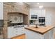 Well-appointed kitchen showcasing a brick arch, tile backsplash, and butcher block island countertop at 10370 Spaight, Chapel Hill, NC 27517