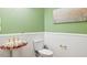 Powder room features a floral pedestal sink and white wainscoting at 10370 Spaight, Chapel Hill, NC 27517