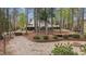 Beautiful backyard with landscaping, fire pit, and multi-level decks surrounded by mature trees at 104 Stage Line Cv, Louisburg, NC 27549