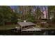 Covered boat dock on the water with boat, seating and lovely home in the background at 104 Stage Line Cv, Louisburg, NC 27549