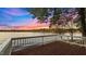 Waterfront deck showcasing beautiful lake view with white railings and scenic sunrise background at 104 Stage Line Cv, Louisburg, NC 27549