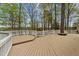 Wide angle view of large wooden deck nestled amongst mature trees and foliage at 104 Stage Line Cv, Louisburg, NC 27549