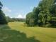 Expansive golf course fairway surrounded by trees, offering a serene and challenging experience for golfers at 104 Stage Line Cv, Louisburg, NC 27549