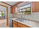 Kitchen features granite counters, a stainless steel sink, and a view of the backyard at 104 Stage Line Cv, Louisburg, NC 27549