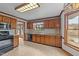 Traditional kitchen with wood cabinetry, black appliances, and a large window offering outdoor views at 104 Stage Line Cv, Louisburg, NC 27549