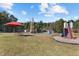 Vibrant playground featuring a slide, swings, climbing frame and red umbrella picnic area, perfect for Gathering fun at 104 Stage Line Cv, Louisburg, NC 27549