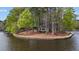 Waterfront property featuring a gazebo nestled among mature trees along the shore at 104 Stage Line Cv, Louisburg, NC 27549