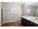 Bathroom featuring a double sink vanity, window and glass enclosed shower at 109 Wyeth Meadows Ln, Holly Springs, NC 27540