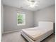 Bedroom features neutral carpet, ceiling fan, and window overlooking the backyard at 109 Wyeth Meadows Ln, Holly Springs, NC 27540