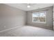 Empty bedroom features neutral carpet, ceiling fan, a window offering natural light, and a closet at 109 Wyeth Meadows Ln, Holly Springs, NC 27540