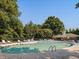 Inviting community pool surrounded by lush trees and lounge chairs, perfect for relaxation and recreation at 109 Wyeth Meadows Ln, Holly Springs, NC 27540