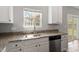 Kitchen boasts granite countertops, stainless steel appliances, white cabinetry, sink and natural light at 109 Wyeth Meadows Ln, Holly Springs, NC 27540