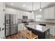 Modern kitchen with stainless steel appliances, granite countertops, and a central island, perfect for cooking and entertaining at 109 Wyeth Meadows Ln, Holly Springs, NC 27540