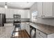 A bright, modern kitchen featuring granite countertops, stainless steel appliances and ample cabinet space at 109 Wyeth Meadows Ln, Holly Springs, NC 27540