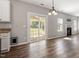 An open floor plan showcasing the living room with wood floors, sliding doors and view to the kitchen at 109 Wyeth Meadows Ln, Holly Springs, NC 27540