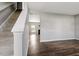 Bright, open-concept living space with neutral walls, hardwood floors, and stairway access, offering modern comfort at 109 Wyeth Meadows Ln, Holly Springs, NC 27540