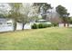 Spacious backyard featuring a white fence, lush green grass, and mature trees at 1104 W Cole St, Dunn, NC 28334