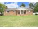 Charming brick ranch home with a front porch, swing, and well-manicured lawn at 1104 W Cole St, Dunn, NC 28334