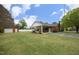 View of the exterior with a covered carport, detached garage, and a well-manicured lawn at 1104 W Cole St, Dunn, NC 28334