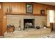 Close-up of a stone fireplace with decorative items, hardwood mantel, and stone hearth at 1104 W Cole St, Dunn, NC 28334